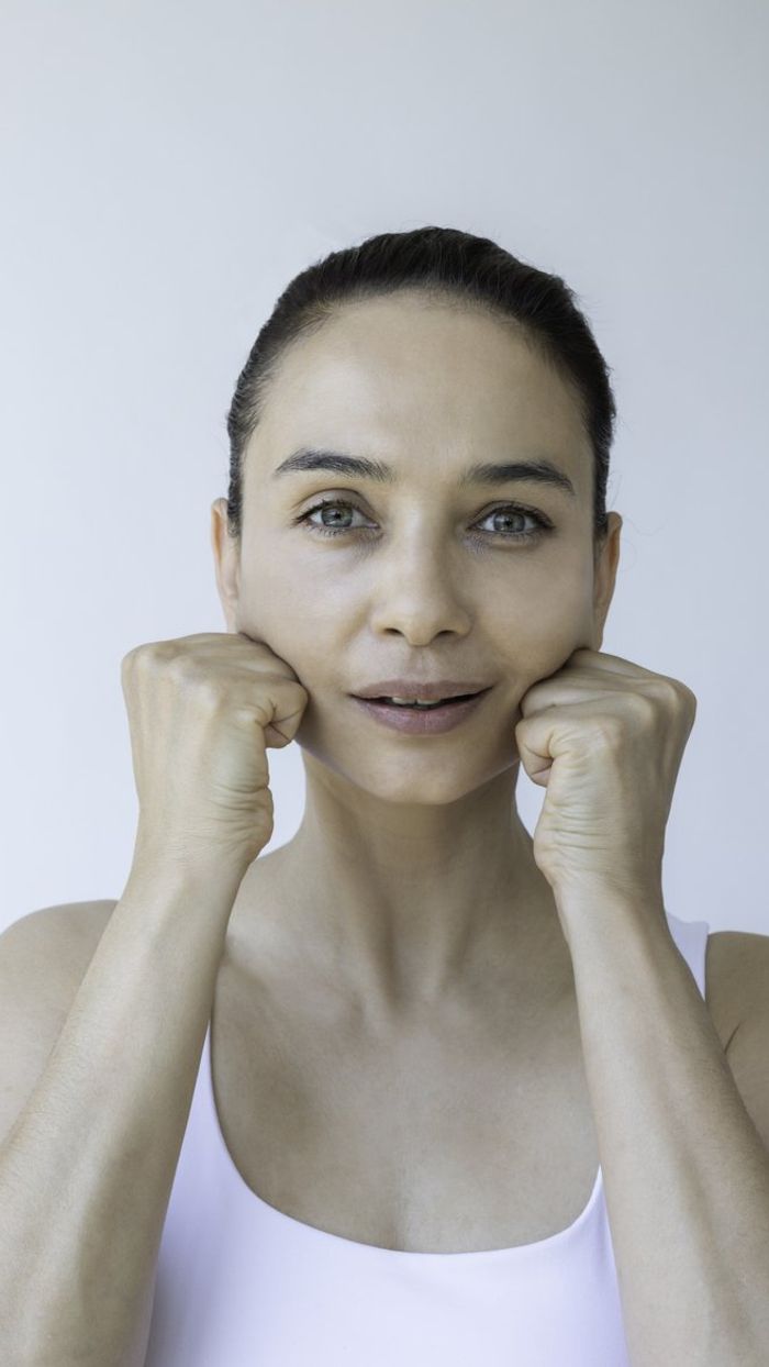 woman is doing facial yoga gymnastics for non surgical rejuvenation